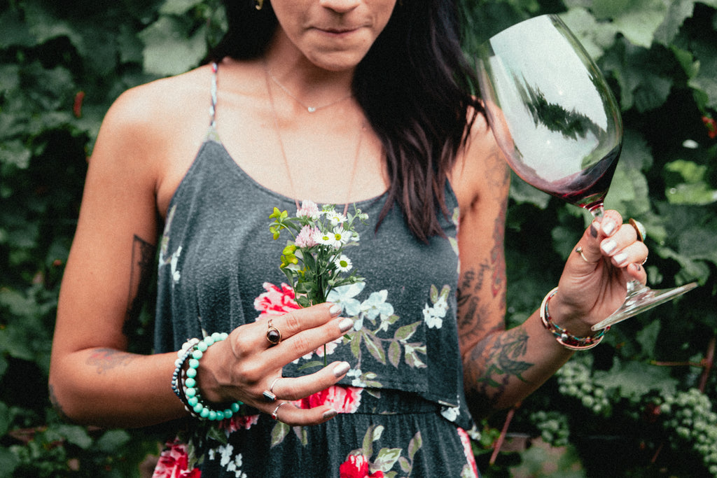 womens-fashion-tattooed-woman-holding-flowers-and-wine